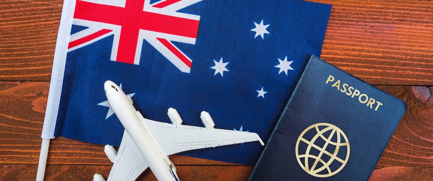 Traveler reviewing Australia visa application documents at a desk with a Dubai skyline in the background, preparing for a tourist visa to Australia.