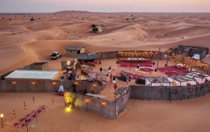Tourists enjoying a thrilling Desert Safari Dubai with 4x4 dune bashing, camels, and a golden sunset over the vast Dubai desert landscape.