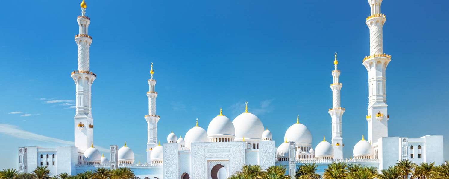 A stunning view of Sheikh Zayed Grand Mosque at sunset, showcasing its majestic domes and intricate architecture. Check the Sheikh Zayed Grand Mosque opening hours and visit the Sheikh Zayed Grand Mosque Centre for an unforgettable experience.