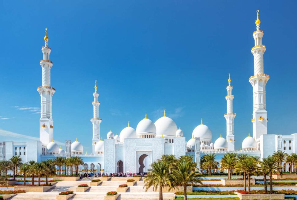 A stunning view of Sheikh Zayed Grand Mosque at sunset, showcasing its majestic domes and intricate architecture. Check the Sheikh Zayed Grand Mosque opening hours and visit the Sheikh Zayed Grand Mosque Centre for an unforgettable experience.