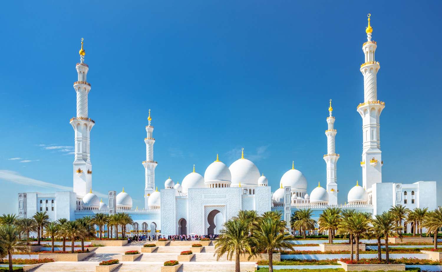 A stunning view of Sheikh Zayed Grand Mosque at sunset, showcasing its majestic domes and intricate architecture. Check the Sheikh Zayed Grand Mosque opening hours and visit the Sheikh Zayed Grand Mosque Centre for an unforgettable experience.