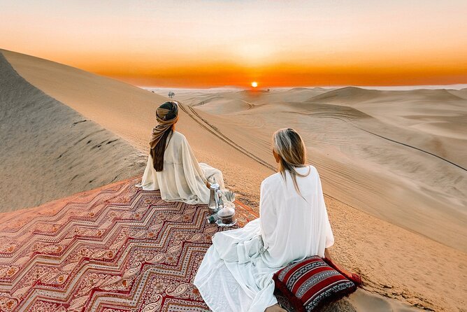 A stunning sunrise over the golden dunes during a Morning Desert Safari in Dubai, featuring a 4x4 vehicle, camel rides, and tourists enjoying the Dubai Morning Desert Safari experience.