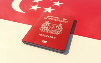 Singapore Visa – Fast 2025 Guide for UAE Residents › Forever Tourism LLC Traveler at airport checking flight details for Dubai to Singapore flight while holding Singapore Visa documents.