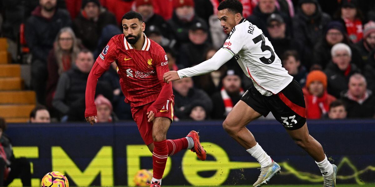 Fans cheering during the Fulham vs Liverpool Premier League match – get your UK visa to witness the next exciting Liverpool match live.