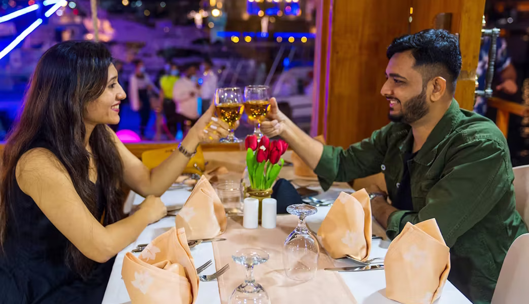 A traditional dhow cruise in Dubai sailing at sunset, offering guests a luxury Dubai cruise dinner and showcasing the best dhow cruise Dubai experience.