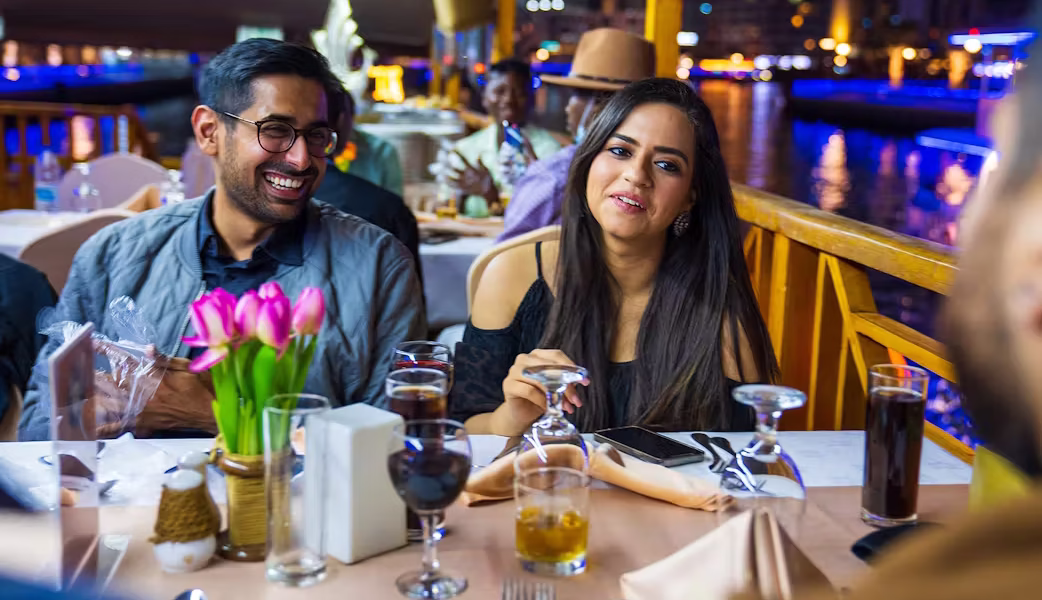 Marina Dhow Cruise With Dinner – Book the Magic! › Forever Tourism LLC Guests dining aboard a traditional dhow during a Marina Dhow Cruise with Dinner in Dubai Marina.