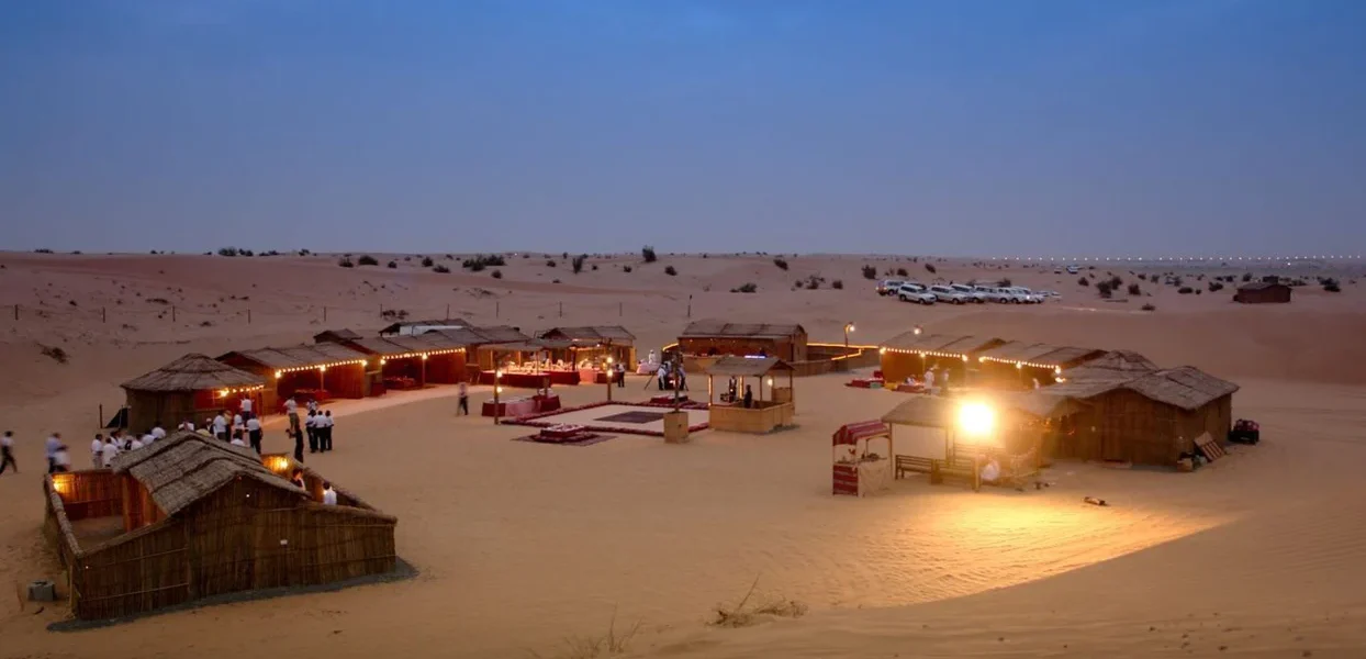 Tourists enjoying a thrilling overnight desert safari Dubai with camel rides, dune bashing, and a sunset view – part of exciting Dubai Desert Safari deals.