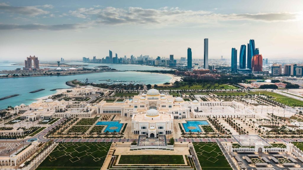 A scenic view of Abu Dhabi city with tourists visiting the grand Sheikh Zayed Mosque during an Abu Dhabi city tour.