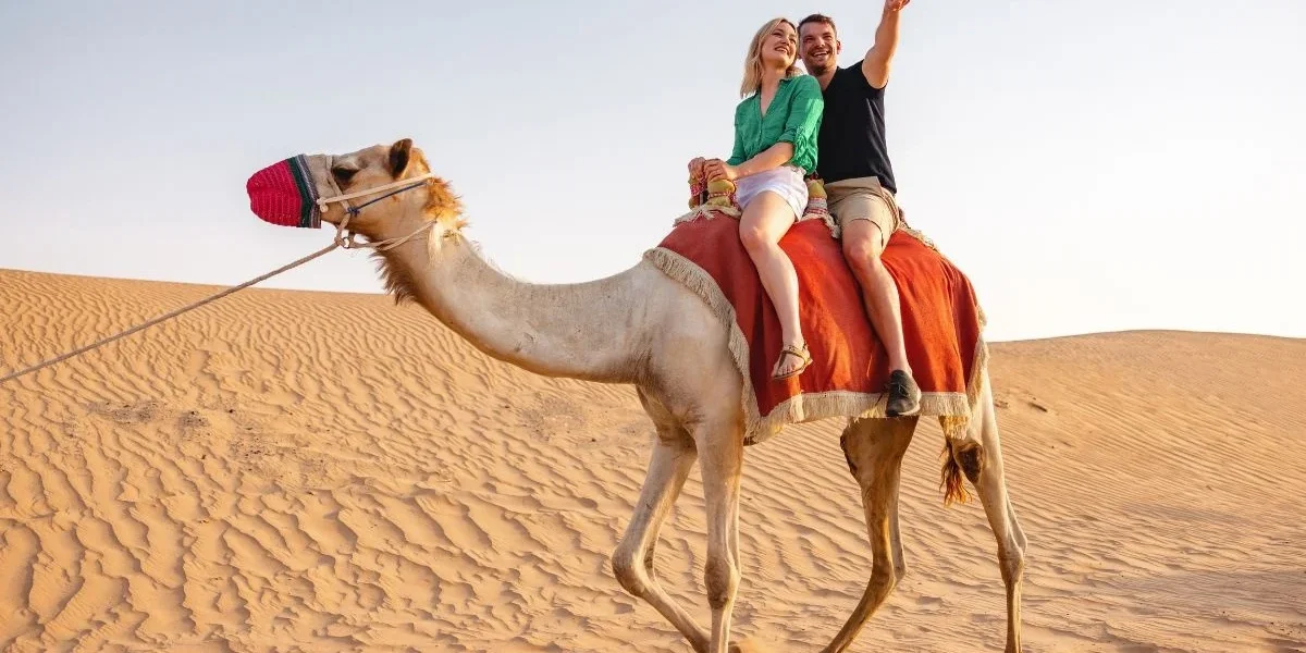 Tourists enjoying the best desert safari in Dubai at a popular desert safari location with sand dunes and 4x4 vehicles.