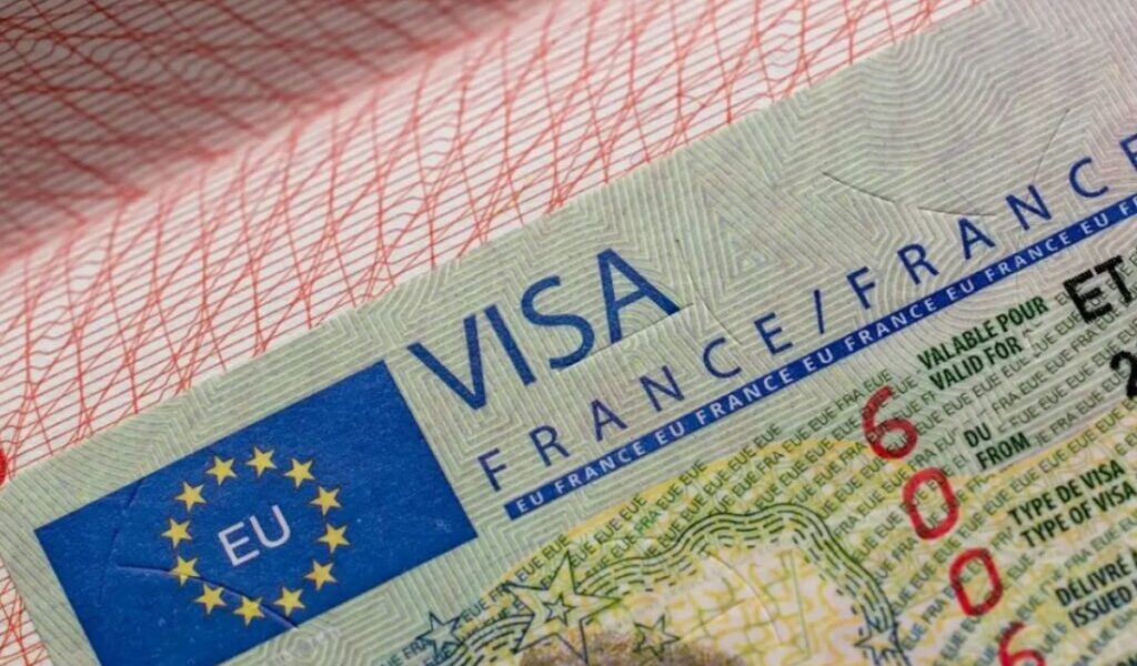 France Visa 2025: Say Bonjour to Your Dream Trip! › Forever Tourism LLC Passport with France visa stamp and travel documents representing the France visa application and tourist visa process.