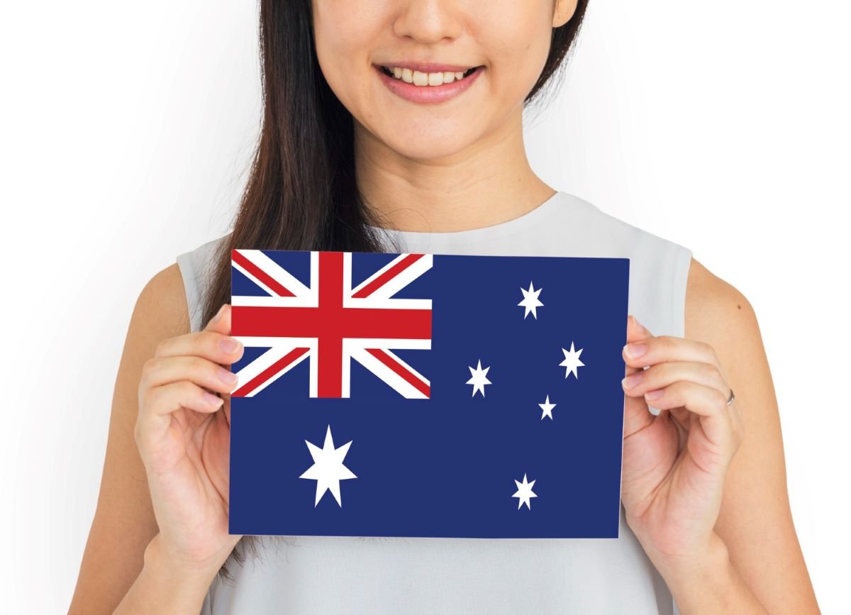 Person holding passport with photo for Australia visa from Dubai, showing correct Australia visa photo size.