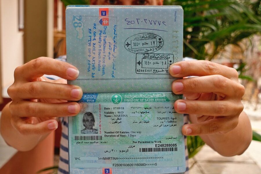 Travelers reviewing Saudi visa restrictions and requirements for tourist visa Saudi Arabia at an airport or visa center.
