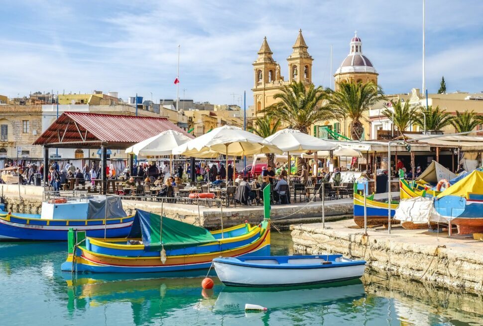 Passport with Malta Schengen visa stamp and travel essentials, representing visa access from Dubai to Malta and other Schengen countries.