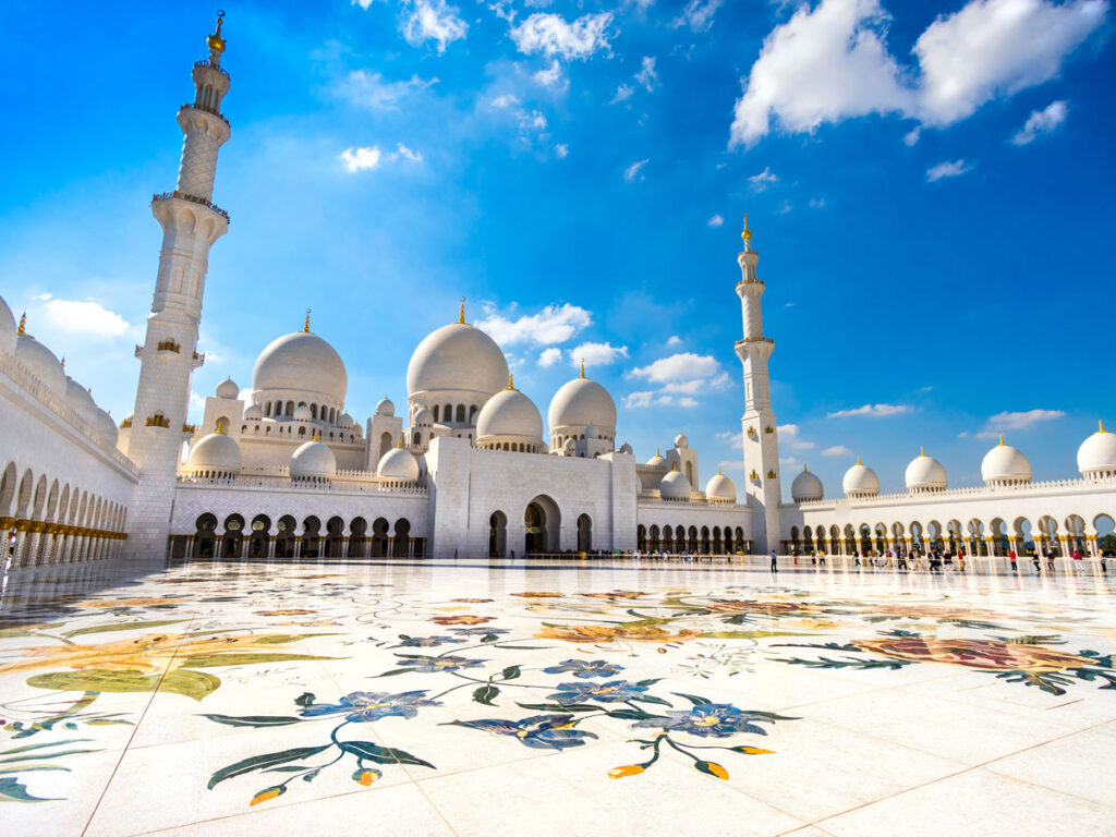 Sheikh Zayed Grand Mosque during Abu Dhabi city tour from Dubai with Ferrari World Yas Island in the background.