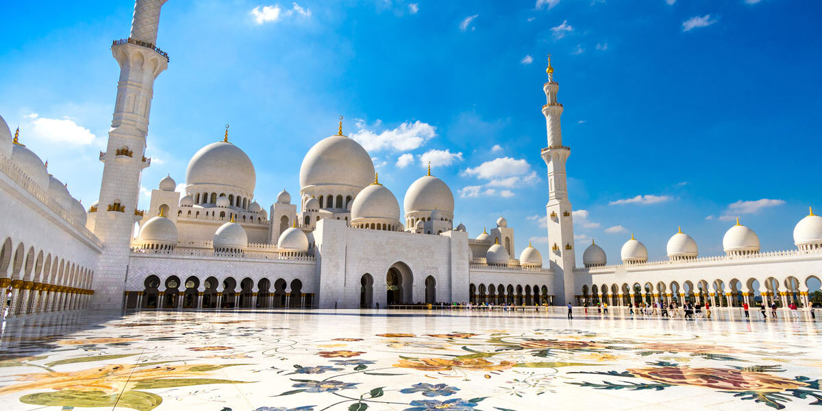 Sheikh Zayed Grand Mosque during Abu Dhabi city tour from Dubai with Ferrari World Yas Island in the background.