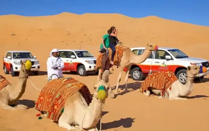 Tourists enjoying a desert safari tour with camel rides and dune bashing during a desert experience Dubai – perfect for desert safari Dubai booking.