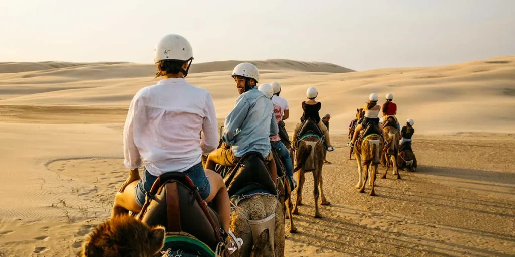 Dubai Desert Safari – Epic Thrill, Book Now! › Forever Tourism LLC Travelers enjoying a thrilling Dubai Desert Safari with dune bashing and camel rides in the vast Dubai desert during a desert safari in Dubai.