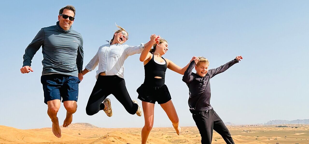 Tourists enjoying quad biking Dubai during a thrilling Desert Safari Dubai with golden dunes and a scenic desert tour backdrop.