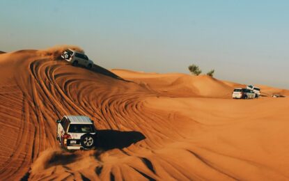 Tourists enjoying a Dubai Desert Safari with dune bashing, camel rides, and scenic views of the vast Dubai desert during sunset.
