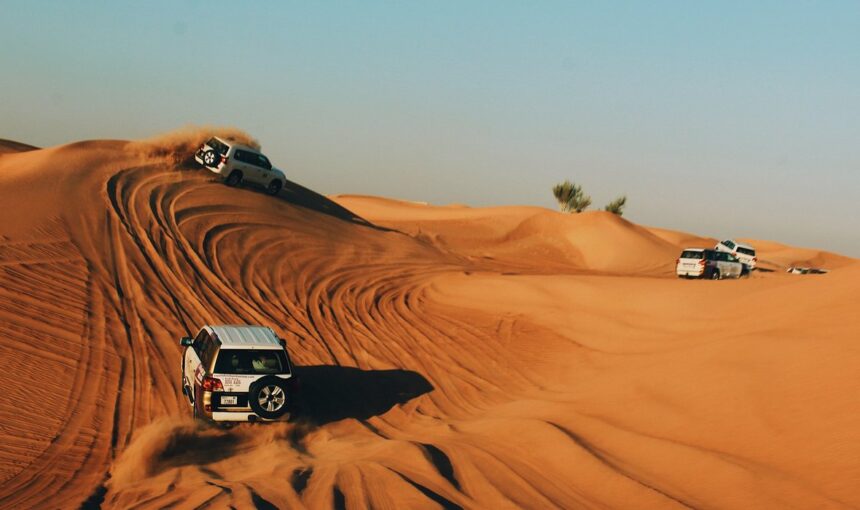 Dubai Desert Safari 2025: Limited Seats, Book Fast! › Forever Tourism LLC Tourists enjoying a Dubai Desert Safari with dune bashing, camel rides, and scenic views of the vast Dubai desert during sunset.