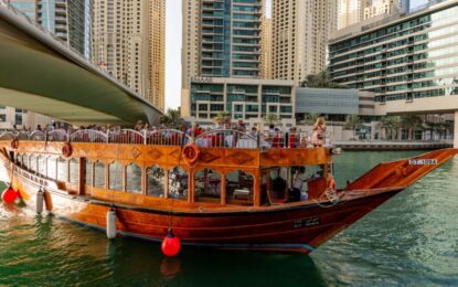 Traditional Dhow Cruise in Dubai sailing at night with guests enjoying dinner and city skyline views.