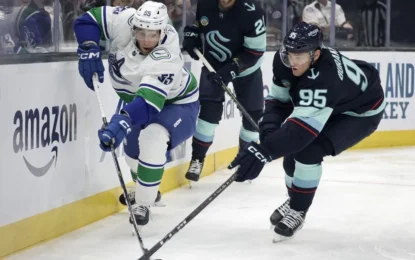 Intense on-ice action during the Kraken vs Canucks game featuring players from Seattle Kraken and Canucks competing for the puck.