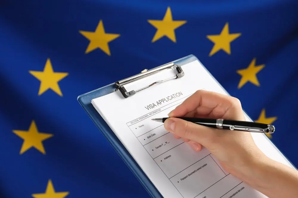 Switzerland Visa – Alps Are Closer Than You Think! › Forever Tourism LLC Travel essentials including passport, flight tickets from Dubai to Switzerland, and Switzerland Schengen visa application documents on a desk.
