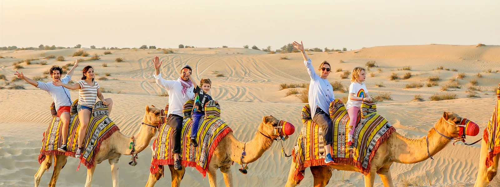 Tourists enjoying a thrilling Desert Safari Dubai ride with scenic desert Dubai dunes in the background – best deals from Dubai.