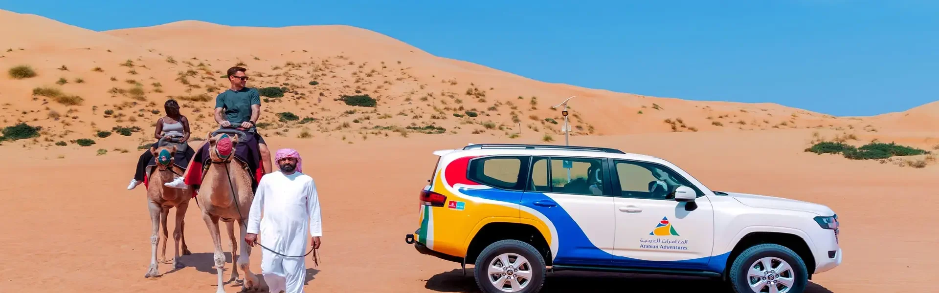 Tourists enjoying a morning desert safari in Dubai with dune bashing and camel rides in the scenic Dubai desert.