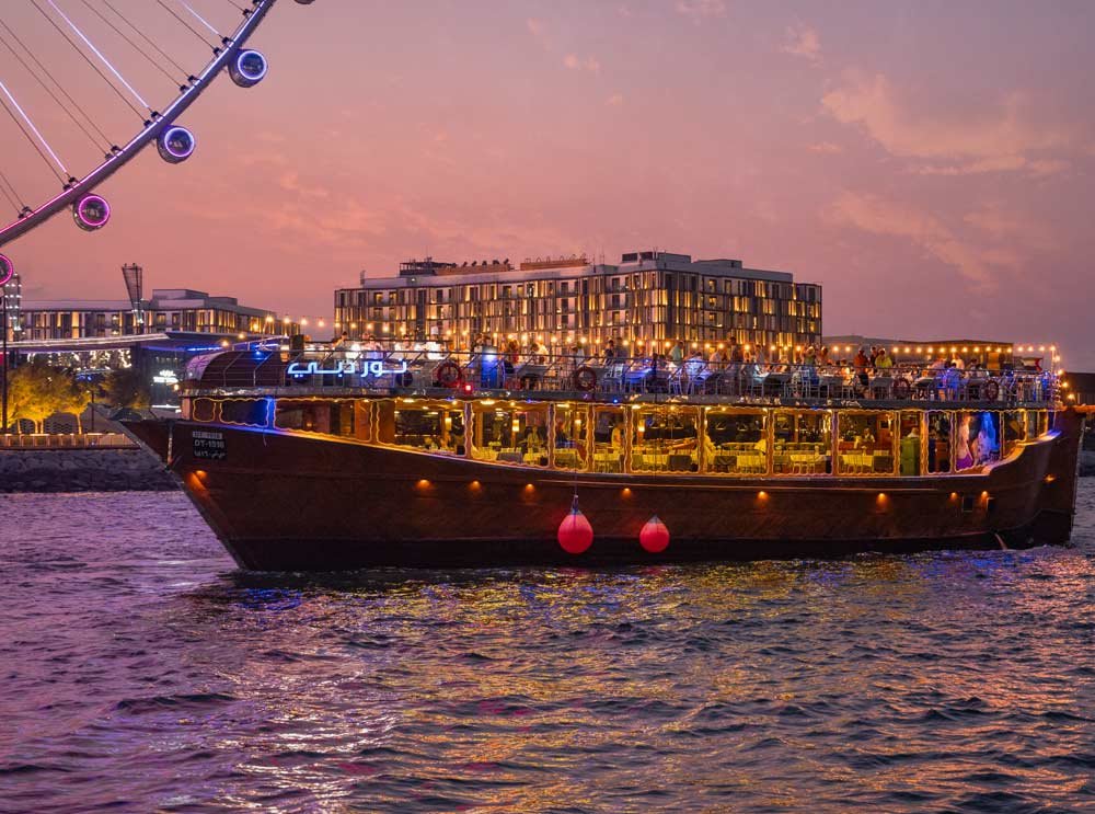Traditional wooden boat sailing during a Marina Dhow Cruise with Dinner on Dubai Marina, offering scenic views and a unique Dhow Dinner Cruise experience.