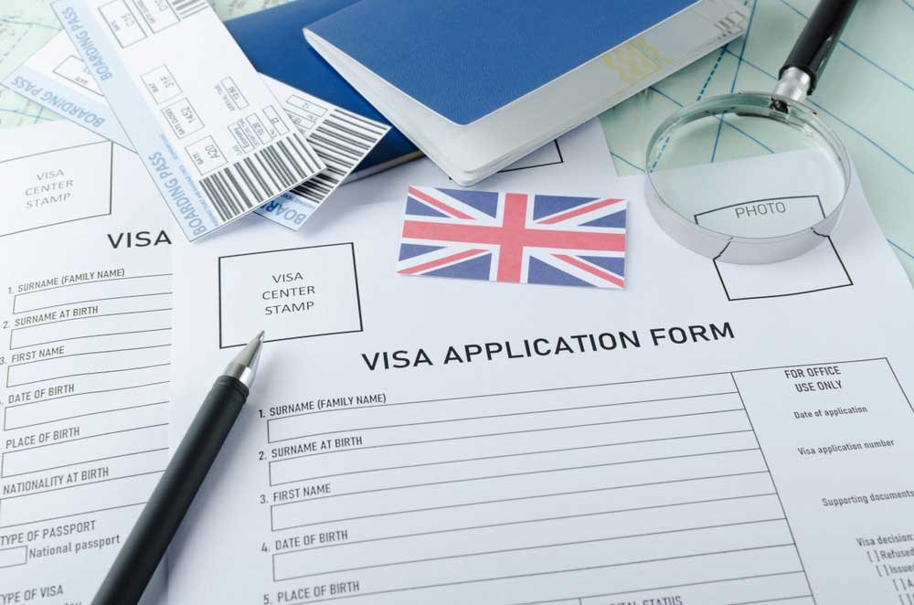 UK Visa from Dubai – 0 hidden fees + 24/7 expert support › Forever Tourism LLC Passport and travel documents with a UK flag, representing the UK visa from Dubai process, UK tourist visa details, and UK visa requirements for UAE residents.