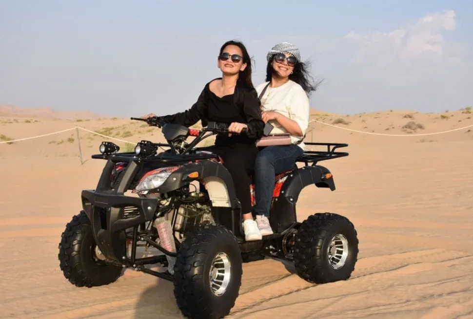 Tourists enjoying a thrilling Desert Safari Dubai experience with dune bashing and camel rides in the heart of the Dubai desert.