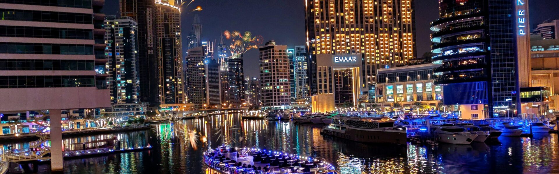 Traditional wooden boat sailing on Dubai Creek during a Dhow Cruise, offering guests scenic views, dining, and entertainment—Dubai Creek Dhow Cruise.