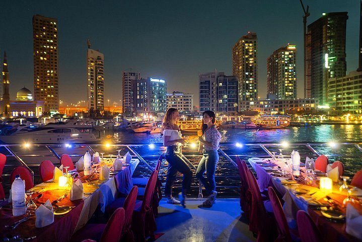 Marina Dhow Cruise With Dinner: 5-Star Views! #500+ › Forever Tourism LLC Traditional wooden boat sailing during a Marina Dhow Cruise with Dinner on Dubai Marina, offering scenic views and a unique Dhow Dinner Cruise experience.