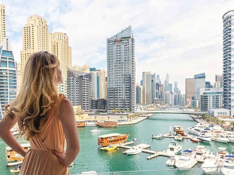 Tourists enjoying a Dubai City Tour Package with Desert Safari Dubai, Dhow Cruise at Dubai Marina, and visiting the Museum of the Future.