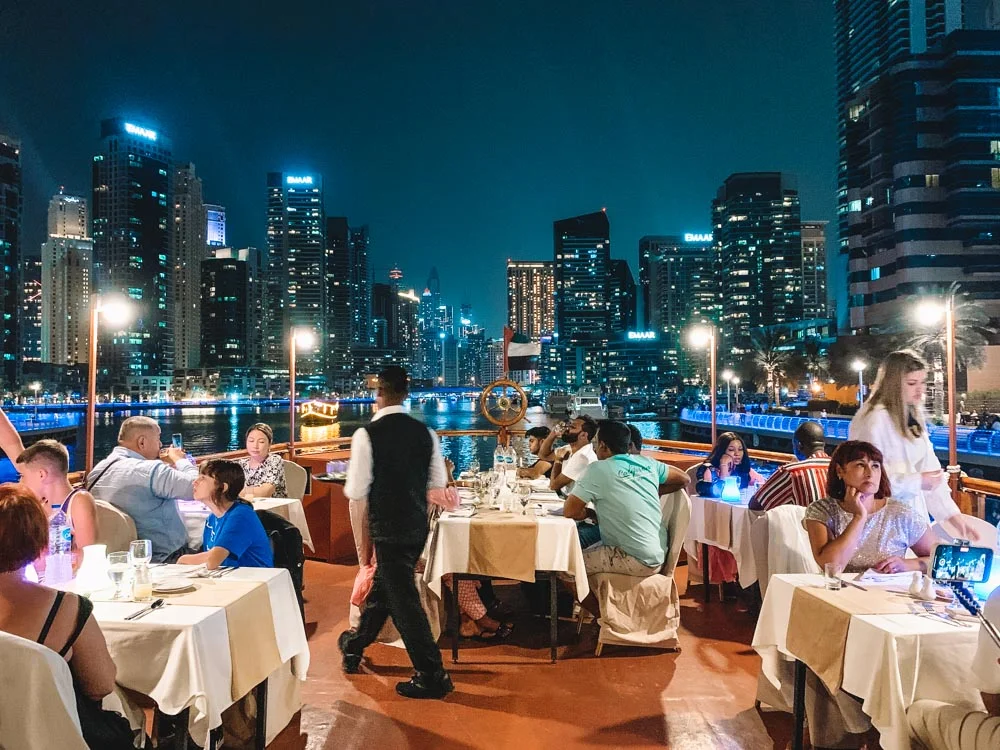 Marina Dhow Cruise: 500+ Reviews Say Must-Do! #TopRated › Forever Tourism LLC Traditional dhow boat sailing through Dubai Marina at sunset during a Marina Dhow Cruise with Dinner.