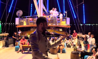 Traditional dhow boat sailing in Dubai Marina during a sunset marina dhow cruise with dinner, with guests enjoying a buffet and scenic views.