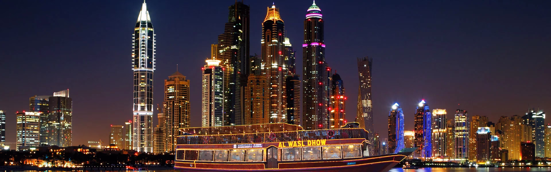 Traditional dhow boat sailing in Dubai Marina during a sunset marina dhow cruise with dinner, with guests enjoying a buffet and scenic views.