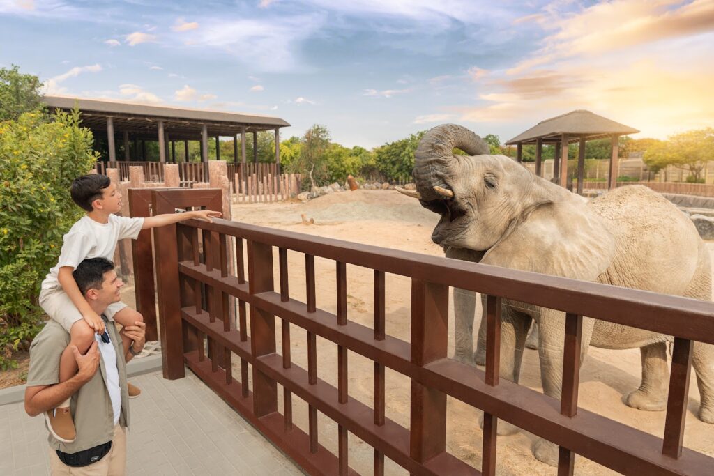 The 7 Best Zoos and Aquariums in Dubai › Forever Tourism LLC Family exploring underwater tunnel at Dubai Aquarium – zoos and aquariums in Dubai