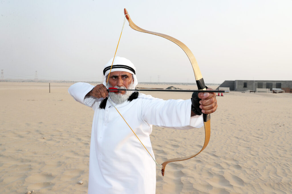 sports in the United Arab Emirates – traditional Emirati men watching camel race