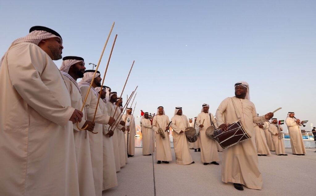 sports in the United Arab Emirates – traditional Emirati men watching camel race