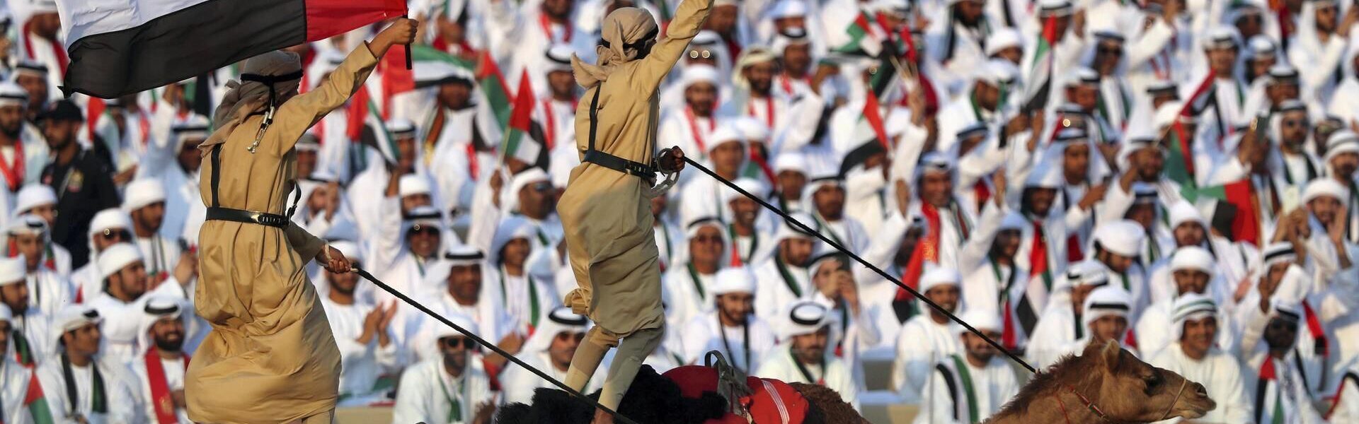 sports in the United Arab Emirates – traditional Emirati men watching camel race