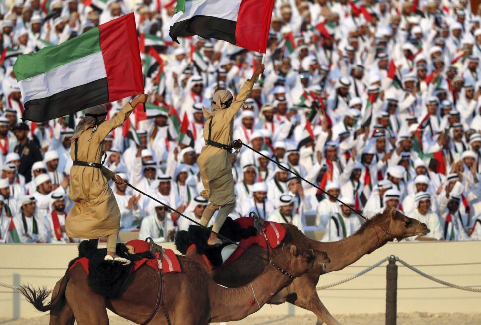sports in the United Arab Emirates – traditional Emirati men watching camel race