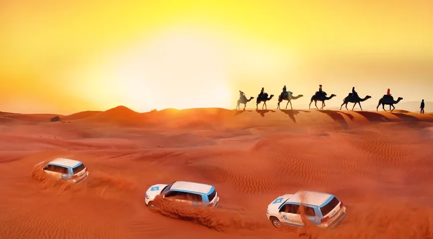 Tourists enjoying dune bashing during an evening safari with the best desert safari company in Dubai, featuring desert camp views and golden sand dunes.