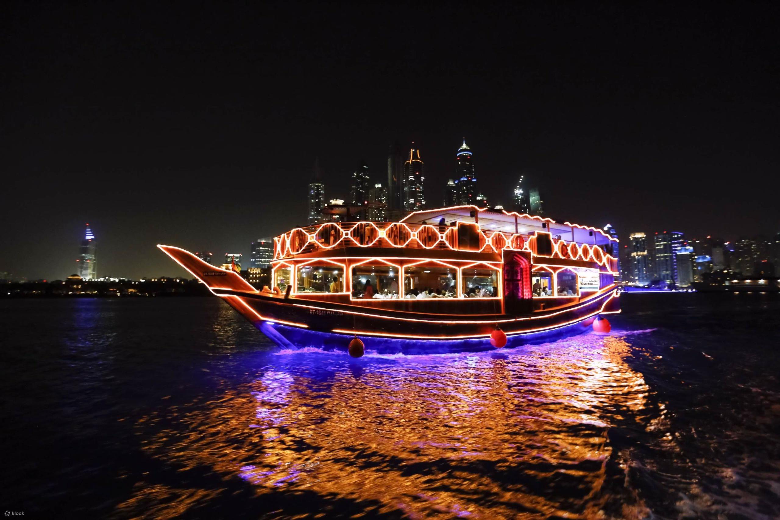 Traditional wooden boat sailing on the Dhow Creek during a scenic creek dhow cruise tour, with guests enjoying a relaxing dhow cruise dinner along the cruise creek.