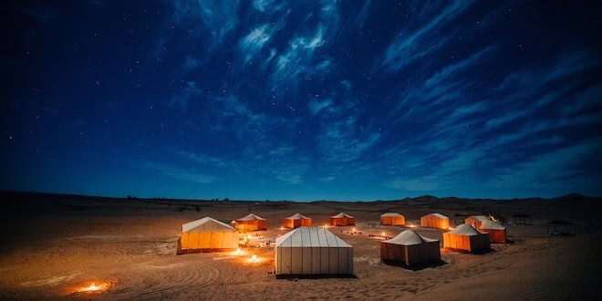 Tourists enjoying a night desert safari Dubai with sand dune bashing, camel trip, and BBQ dinner in the scenic Dubai desert.