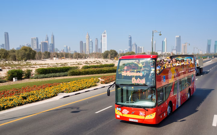 Dubai hop on hop off bus passing iconic landmarks during a Dubai sightseeing city tour.
