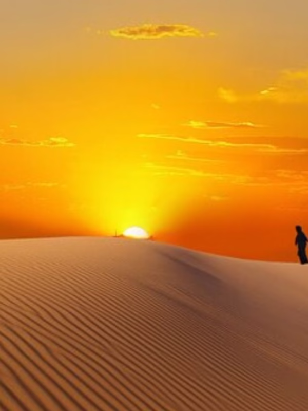 Tourists enjoying a sunrise desert safari Dubai at a scenic desert safari location with views of the golden sand dunes during early morning.
