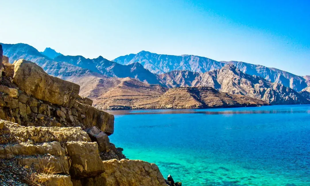 Dhow sailing through Dibba Musandam fjords under the sun – dibba musandam cruise deals
