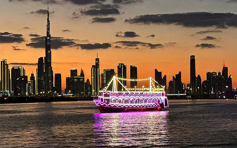 Traditional wooden dhow sailing through Dubai Canal at night – Dubai Canal Dhow Cruise